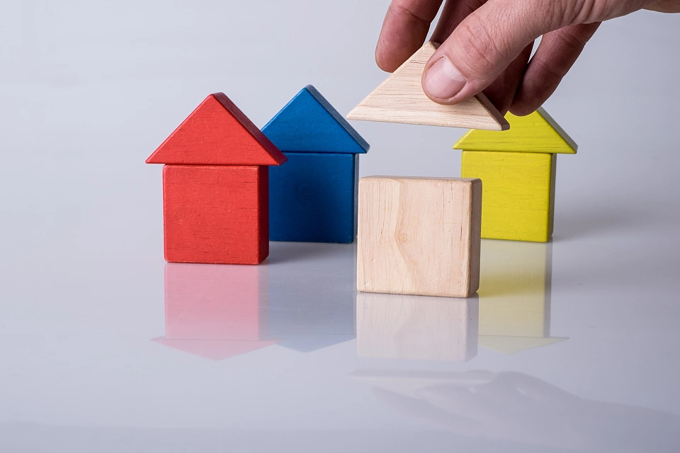 Bunte Baukl&ouml;tze in Form von H&auml;usern.