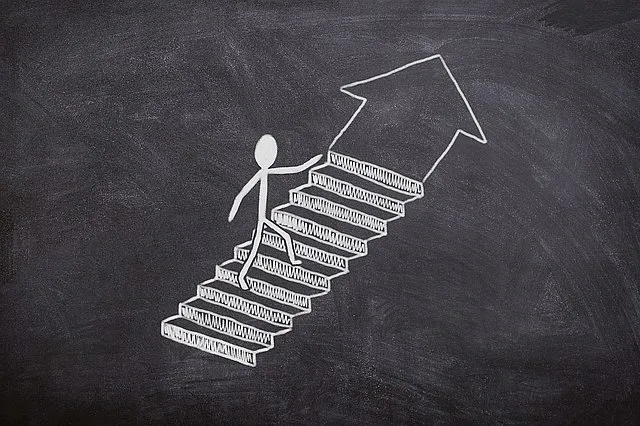 Eine mit Kreide gezeichnete Figur geht eine Treppe hinauf, an deren Ende ein Pfeil nach rechts oben zeigt